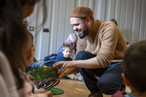 smiling man telling stories to early years